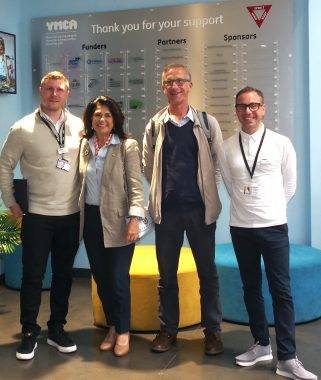 Soheila Hayek Steffen Benbow Peter Posner Joe Piliero stand inside the reception of the YMCA Community and Activity Village