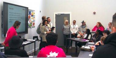 Soheila Hayek Steffen Benbow Peter Posner Joe Piliero stand in a classroom of the YMCA Community and Activity Village with Camp Williams Staff